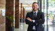 © Generative AI - Confident Young Businessman Smiling with Arms Crossed in a Stylish Modern Office Lobby : Generative AI