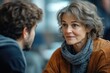 © hkjdesign - A mature woman attentively listens to a younger man, engaging in a serious conversation.