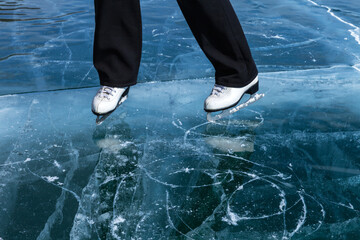 Wall Mural - Winter activity and ice skating on frozen Baikal Lake. Top view of beautiful transparent ice with cracks and white figure skates on surface of icy lake. Winter travels and outdoors. Natural background