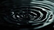 © ae - Close-up of a water droplet creating ripples in a dark pool, evoking tranquility and movement