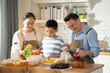 © winnievinzence - Asian grandparents support and help grandson cooking breakfast in the kitchen. Grandmother and grandfather watching nephew learning skill on morning weekend. Family love and bonding.