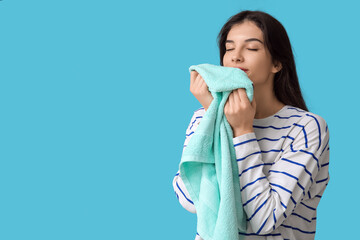 Wall Mural - Beautiful young woman with clean towel on blue background