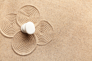 Wall Mural - Stack of spa stones on light sand with pattern