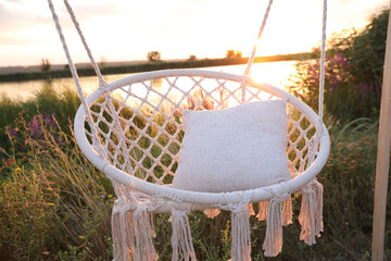 Wall Mural - Beautiful white swing chair outdoors at sunrise