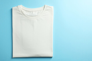 Wall Mural - One blank t-shirt on light blue background, top view. Mockup for design