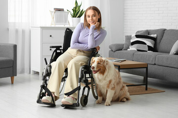 Wall Mural - Beautiful young woman in wheelchair with service dog at home