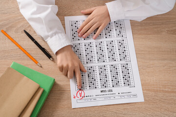 Wall Mural - Schoolboy with results of test on table, top view