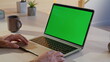 © stockbusters - Entrepreneur watching video green screen laptop at remote workspace closeup.