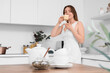 © Pixel-Shot - Young woman with cup of tasty tea in kitchen