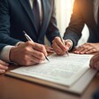© Viktor - Close-up of group of businesspeople signing legal documents with pen at desk. Team conclude contract. Pro lawyers read paperwork. Concept of business agreement.