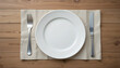 © rdkcho - Simple Table Setting with White Plate and Silverware on Wooden Table