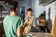 © Marko Geber - Lesbian couple washing dishes together in modern kitchen