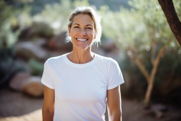 Smiling happy middle aged Caucasian woman wearing a white t shirt outside