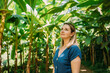 © Svetlana - A young woman walking along a tropical path surrounded by banana trees