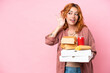 © luismolinero - Young caucasian woman holding fast food isolated on pink background listening to something by putting hand on the ear