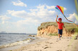 © New Africa - Cute little child with kite running on beach near sea. Spending time in nature