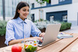 © Xavier Lorenzo - Happy businesswoman working on laptop sitting outside building office. Business and education concept.