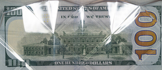 Poster - US 100 dollar banknote under transparent curved plastic