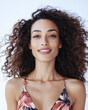 © Chari - Woman with curly hair smiles brightly against a light background