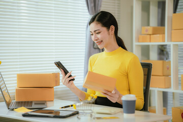 Portrait of Starting small businesses SME owners female entrepreneurs working on receipt box and check online orders to prepare to pack the boxes, sell