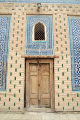 Wall Mural - Ancient Uzbek architecture with carved wooden door , windows and blue ceramic tiles in Khiva , Uzbekistan