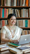 © Mads - A photograph of an Indian woman in her late thirties, smiling as she works on a laptop at her office desk