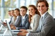 © Vera - Young Business Professionals Sitting Together and Using Computers with Smiles