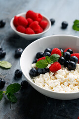 Wall Mural - Bowl of cottage cheese, curd cheese with blueberry and raspberry. High protein healthy breakfast or lunch