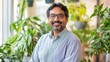© Denisa - A South Asian man in his 40s thrives in a tidy, plant-filled home office