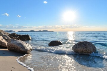 Wall Mural - Scenic beach with rocky shoreline and calm waves in bright sunlight
