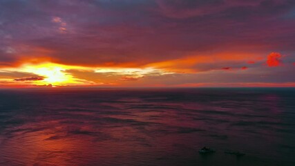 Wall Mural - aerial view of sea surface during a dramatic red sunset, timelapse, 4k