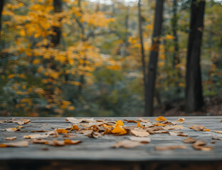 Wall Mural - Rustic autumn tableau featuring golden leaves strewn across weathered wooden planks with a serene forest backdrop, capturing nature's seasonal transformation