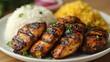 © Laongdouw - A delicious plate featuring grilled chicken, fragrant rice, and vibrant yellow rice. The dish is garnished with fresh herbs, perfect for a satisfying and nutritious meal.