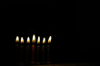 © alexkich - Seven Burning Candles in the Dark - Symbol of Light and Hope in Black Background