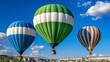 © A4719 - Three colorful hot air balloons float against a vibrant blue sky dotted with fluffy white clouds, over a landscape of light beige and tan hills