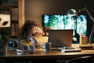 Woman falling asleep in front of the laptop