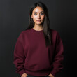 © suriyani - a woman wearing a plain maroon sweatshirt. isolated on a gray studio photo background