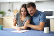 © Antonioguillem - Interracial couple signing contract in the kitchen