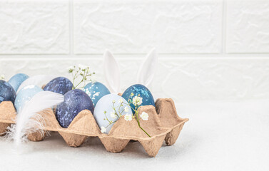 Wall Mural - easter eggs with blossoms spring flowers in paper tray on a white background. easter card. top view.