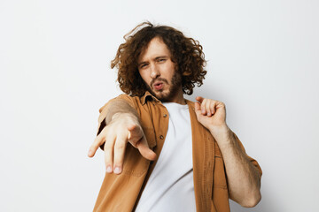 Stylish young man in casual attire expressing joy and confidence against a minimalist background, highlighting emotion and creativity in fashion