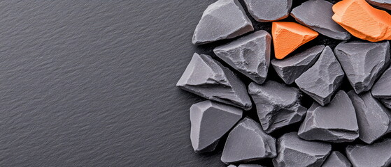 Aufkleber - Dark Slate Surface with Round Arrangement of Gray Stones and a Bright Orange Element Highlighting Contrast
