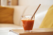 © Madeleine Steinbach - A glass of fresh carrot juice with ecological bamboo straw in a living room