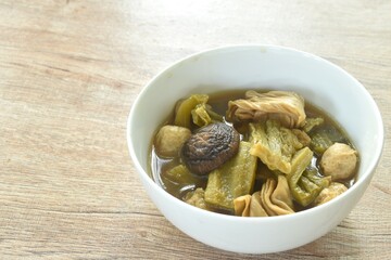 Wall Mural - boiled pickled cabbage and bitter cucumber with tofu topping black mushroom in Chinese herb soup on bowl 