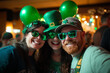 © idcreative.ddid - Group of diverse friends enjoying at party in the bar and taking selfie with smart phone. People partying and celebrating St. Patrick’s Day at night club.