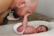 © Westend61 - Father embracing cute baby daughter lying in crib at home