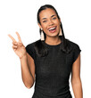 © Asier - Young Filipina in black evening dress joyful and carefree showing a peace symbol with fingers.