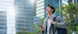 © Yingyaipumi - smiling happy successful asian businessman or lawyer in gray suit and blue shirt calling with his phone near his ear standing in front of an office building.Successful businessman holding mobile phone