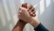 © TransPicHub - Two diverse hands clasped together symbolizing unity and friendship.