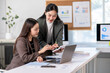 © Wasana - Two women are working together at a desk with a laptop and a stack of papers