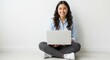 © EZPS - A smiling young woman sitting cross-legged with a laptop on a white background, embodying a casual business concept